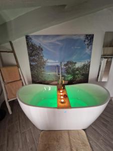 a bathroom with a bath tub with a painting on the wall at El Pitijopo in El Gastor