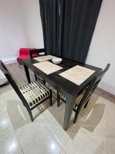 a black table and chairs with a black curtain at Departamento Centro Jujuy 2 in San Salvador de Jujuy +3 photos