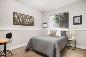 Un dormitorio blanco con una cama y una ventana. en Cesar's Townhome, en Portland
