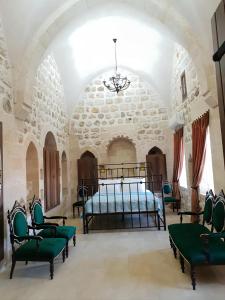 a bedroom with a bed and chairs in a room at Mardin tarihi ulu Cami yanı, tarihi Konak in Mardin