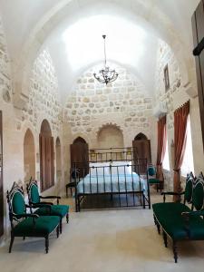 a bedroom with a bed and chairs in a room at Mardin tarihi ulu Cami yanı, Kale divan konağı in Mardin