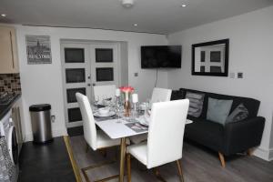 a dining room with a table and a couch at The Cosy Corner 2 Bedroom flat in Sheffield