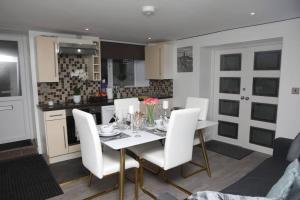 une salle à manger avec une table blanche et des chaises blanches dans l'établissement The Cosy Corner 2 Bedroom flat, à Sheffield