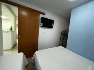 a bedroom with a bed and a tv on the wall at Hospedagem BRASILIANAS in Brasilia