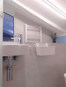 ein weißes Bad mit einem Waschbecken und einem Fenster in der Unterkunft LITTLE SKY in Madrid