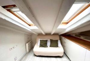 ein kleines Schlafzimmer mit einem Bett in einem Zimmer mit Oberlichtern in der Unterkunft LITTLE SKY in Madrid