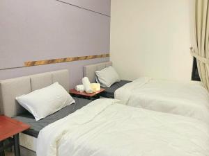two beds in a hotel room with white sheets at 1 Dream Home @ Tiara Imperio 两间房舒适环境适合家庭和旅行 in Kajang