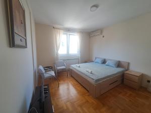 een kleine slaapkamer met een bed en een raam bij Apartman Quality in Voždivac