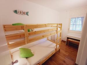 1 Schlafzimmer mit 2 Etagenbetten und grünen Kissen in der Unterkunft Apartamento con piscina cerca de la playa in Pals