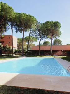 a large blue swimming pool with trees in the background at Apartamento con piscina cerca de la playa in Pals