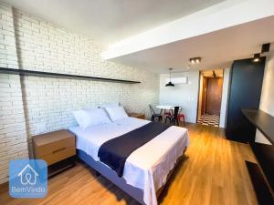 a bedroom with a bed and a brick wall at Apartamento completo com píer e acesso ao mar in Salvador