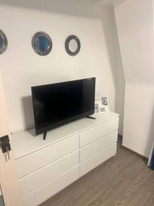 a flat screen tv sitting on top of a white dresser at Apartament ultra central in Craiova