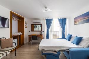 een slaapkamer met een bed, een bank en een bureau bij B&B Antica Napoli in Napels