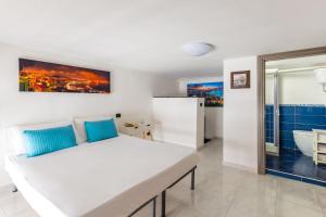 een slaapkamer met een wit bed en een badkamer bij B&B Antica Napoli in Napels