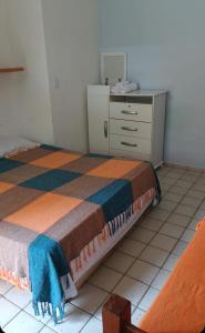 ein Schlafzimmer mit einem Bett und einer Kommode darin in der Unterkunft Pousada jardim de cabo branco in João Pessoa