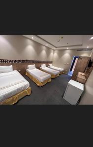 a room with four beds in it with a window at فندق قافلة الحجاز in Makkah