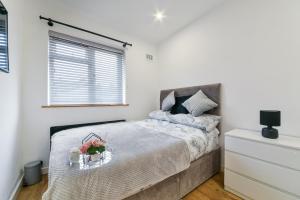 Un dormitorio con una cama y una bandeja con flores. en Bromley Palace - Entire 2 Bed House - Free Parking - Self Check-in, en Londres
