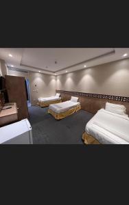 a room with three beds in a room at فندق قافلة الحجاز in Makkah