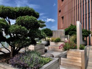 a garden with trees and flowers in front of a building at Manhattan Loft Gardens, Stratford in London