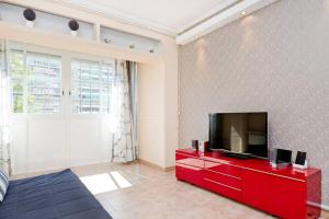 ein Wohnzimmer mit einem Flachbild-TV auf einem roten Schrank in der Unterkunft Glorias:Sagrada Familia 15 minutos - Playa 20 minutos in Barcelona
