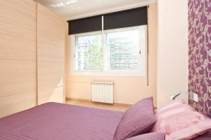 ein Schlafzimmer mit einem lila Bett und einem Fenster in der Unterkunft Glorias:Sagrada Familia 15 minutos - Playa 20 minutos in Barcelona