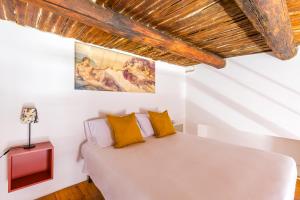een slaapkamer met een wit bed met gele kussens bij B&B Antica Napoli in Napels
