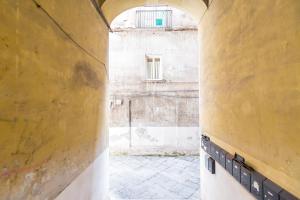 een steegje in een oud gebouw met een raam bij B&B Antica Napoli in Napels +79 foto's