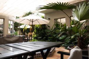 un patio con mesa, sombrilla y plantas en Hotel Copahue en Junín