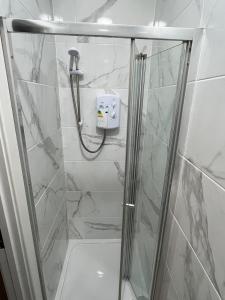 a shower with a glass door in a bathroom at Halloway Guest Studio 54 in London