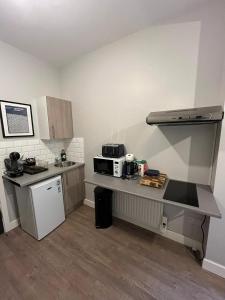 a small kitchen with a counter and a microwave at Halloway Guest Studio 54 in London