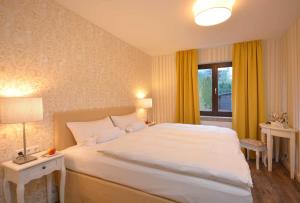 a bedroom with a large white bed and a window at Hotel am Kirchplatz in Sachsenheim
