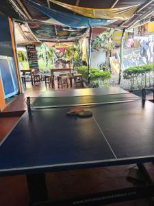 a ping pong table in a room with tables and chairs at Hostel La Casona Don Juan in San Gil