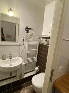 a bathroom with a sink and a toilet and a mirror at Apartment mit Terrasse iP-TV Stellplatz in Krefeld