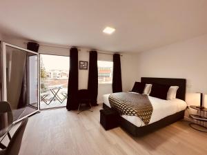 1 dormitorio con 1 cama y balcón en Living Funchal iNN en Funchal