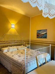 1 dormitorio con cama blanca y pared amarilla en La valle incantata, en Villanova dʼAsti