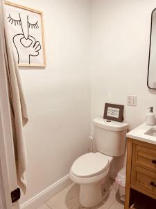 a white bathroom with a toilet and a sink at 2Beds Apt walking distance to major hospitals - heart of Morris Park - Bronx 30 days plus in Morris Park