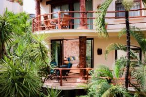 a house with a balcony with palm trees at Villas Sacbe Condo Hotel and Beach Club in Playa del Carmen