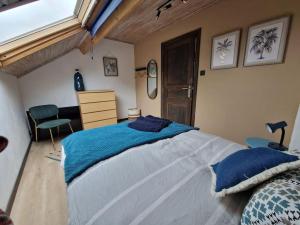 1 dormitorio con 1 cama grande con almohadas azules en Maison familiale avec jacuzzi et jardin au calme, en Sprimont