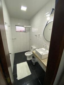 a bathroom with a sink and a toilet and a mirror at Prime Hotel in Arcos