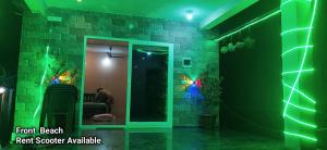 a room with a green lighting and a room with a mirror at S B h in Gokarn