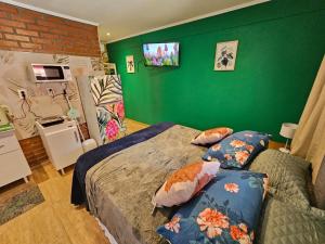 a bedroom with two beds and a green wall at Casa 24 Puerto Iguazu in Puerto Iguazú