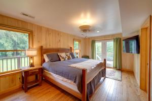 Riverfront West Virginia Cabin with Screened-In Deck في Marlinton: غرفة نوم بسرير وشرفة