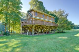 Riverfront West Virginia Cabin with Screened-In Deck في Marlinton: منزل كبير مع التفاف حول الشرفة