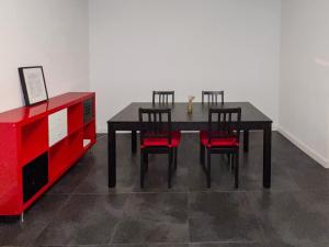 een eettafel met 4 stoelen en een rode dressoir bij Appart'Hotel Le Maréchal - 3 frontières & Netflix in Huningue