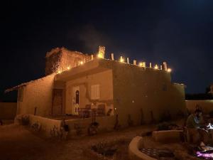 a house with lights on top of it at night at Friendo's House & Hot Spring in Siwa