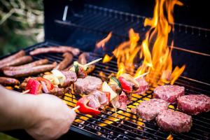 a person cooking meat and vegetables on a grill at Résidence Le Marlodj in Mar Lodj