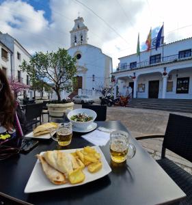 a table with a plate of food and two glasses of beer at El Pitijopo in El Gastor
