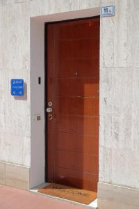 Una puerta marrón en un edificio con un cartel. en La Ca' Fiera Affittaly Apartments en Bolonia