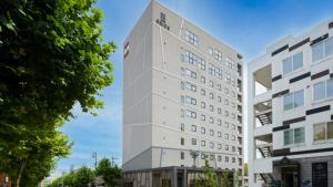 a tall white building next to two buildings at GRIDS Premium Hotel Otaru - Vacation STAY 68545v in Otaru