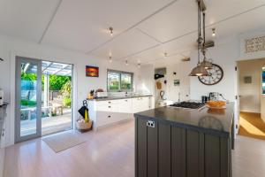 a kitchen with white cabinets and a counter top at Omiha Oasis with seaviews and spa pool in Omiha +15 photos